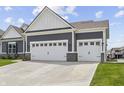 Spacious three-car garage with white doors and ample parking space on driveway at 19405 Titus Dr, Westfield, IN 46074