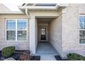 Inviting front entryway featuring brick accents and a covered porch, offering a warm welcome at 20133 Willenhall Way, Westfield, IN 46074