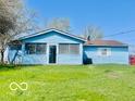 Rear view of a light blue single-story home with an expansive lawn and a clear blue sky at 213 Harrell Dr, Edinburgh, IN 46124