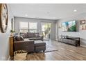 Cozy living room featuring wood-look floors, large sectional couch, entertainment center and sliding doors to patio at 2936 W Calimanco Ln, Monrovia, IN 46157
