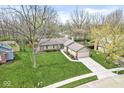 Aerial shot of a ranch style house with mature trees, a well kept lawn, and an attached two car garage at 334 Stonehedge Dr, Carmel, IN 46032