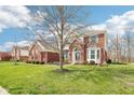 Attractive brick home with manicured lawn and mature trees, showcasing a welcoming entrance and classic curb appeal at 3932 Long Ridge Blvd, Carmel, IN 46074