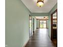 Hallway with wood floors and natural light flowing into the living room with a brick fireplace and wood beams at 3991 Clubhouse Dr, Greenfield, IN 46140