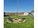 Backyard with firepit, outdoor seating, and a storage shed under a clear blue sky at 422 Hege Ave, Columbus, IN 47201