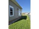 View of the side yard with green grass and gravel adjacent to the house and shed in background at 422 Hege Ave, Columbus, IN 47201