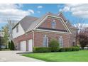Attractive brick home with a three-car garage, well-kept lawn and trimmed hedges at 4281 Honeysuckle Ln, Zionsville, IN 46077