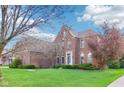 Beautiful two-story brick home with a well-maintained lawn and mature trees at 4281 Honeysuckle Ln, Zionsville, IN 46077