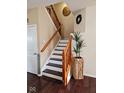 Elegant staircase with wooden handrail, decorative accents, and modern lighting at 4383 Round Lake Bnd, Indianapolis, IN 46234