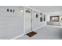Cozy front porch featuring a modern security door, stylish wall lanterns, and a welcoming doormat at 443 N Alton Ave, Indianapolis, IN 46222