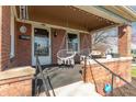 Inviting front porch with two hanging chairs, a brick facade, and an ADT security system sign at 504 S Lebanon St, Lebanon, IN 46052
