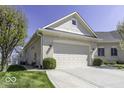 Angle view of a single-story home featuring an attached garage, manicured lawn, and blossoming trees under a clear blue sky at 537 Weyworth Pl, Greenwood, IN 46142