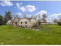 Inviting exterior featuring stone, siding, manicured lawn, patios, and landscaped flower beds at 5455 S 800 E, Zionsville, IN 46077