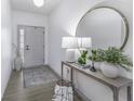 Bright entryway featuring a stylish console table, decorative lamps, and a round mirror, creating an inviting ambiance at 561 Riviera Pl, Greenwood, IN 46143