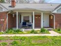 Inviting front porch with seating, brick facade, and well-maintained landscaping at 575 Crestpoint Ln, Plainfield, IN 46168