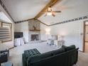 Comfortable living room featuring a brick fireplace, beamed ceiling, and neutral carpeting at 575 Crestpoint Ln, Plainfield, IN 46168