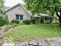Beautiful stone exterior of a well-maintained home with mature trees and landscaping at 5846 Bellsville Pike, Columbus, IN 47201
