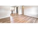 Bright living room with wood-look flooring and an open doorway to the kitchen with stainless steel appliances at 6189 Vigo Dr, Clayton, IN 46118