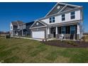 A two-story home featuring a brick facade, attached two car garage, and covered porch at 7628 Big Bend Blvd, Camby, IN 46113