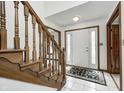 Inviting foyer featuring tiled floors, a wooden staircase, and a white front door with decorative glass panels at 7688 Gunsmith Ct, Plainfield, IN 46168