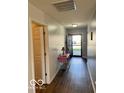 Inviting hallway with wood floors leading to the home's entrance at 8019 Gathering Ln, Indianapolis, IN 46259