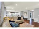 Comfortable living room with hardwood floors, neutral walls, and an open view to the kitchen at 902 Helm Dr, Avon, IN 46123