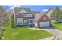 Charming two-story brick home with lush green lawn, driveway, and attached two-car garage at 10471 Meadow Lake Dr, Fishers, IN 46038