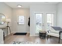 Bright entryway featuring light hardwood floors, a white door, and glass patio doors at 1053 Reserve Way, Indianapolis, IN 46220