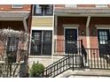Exterior view of red brick townhouses with black doors and black wrought iron railings on concrete steps at 1053 Reserve Way, Indianapolis, IN 46220