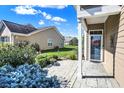 Charming front entryway features a covered porch, a welcoming front door, and landscaped garden beds at 10955 Chapel Woods N Blvd, Noblesville, IN 46060