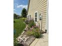 Exterior view of lush landscaping and garden beds along the side of the home on a sunny day at 10955 Chapel Woods N Blvd, Noblesville, IN 46060