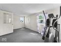 Bedroom with gray carpet, two doors and purple-and-white striped curtains at 1126 N Anderson St, Elwood, IN 46036