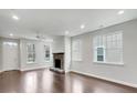 Open concept living room with hardwood floors, stone fireplace, and large windows at 12521 Hawks Landing Dr, Fishers, IN 46037