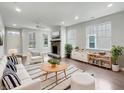 Bright living room with modern fireplace, wood floors, large windows, and stylish decor at 12521 Hawks Landing Dr, Fishers, IN 46037