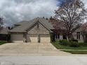 A brick home with a three car garage and mature trees at 1304 Park Meadow Dr, Beech Grove, IN 46107