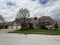 A brick home with a three car garage and mature trees at 1304 Park Meadow Dr, Beech Grove, IN 46107