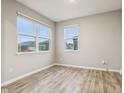 Serene bedroom with wood-look floors, neutral walls, and plenty of natural light from the two windows at 1862 Downey Ln, Greenfield, IN 46140