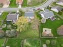 An aerial view showcasing the home's lush green lawn, mature trees, and neighborhood surroundings at 24 W Pine Ridge Dr, Westfield, IN 46074
