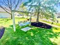 Relaxing backyard featuring a wooden swing set beneath a mature tree, offering a serene spot for outdoor enjoyment at 2509 Windsor Ct, Lebanon, IN 46052