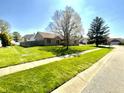 Spacious front yard showcasing a lush green lawn, mature trees, and sidewalk leading to this inviting property at 2509 Windsor Ct, Lebanon, IN 46052
