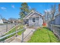 View of light gray home with a chain-link fence and fresh green grass at 2531 E Brookside Ave, Indianapolis, IN 46218