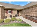 Inviting brick home featuring a charming front porch with seating area and well-manicured landscaping at 2601 Viceroy Ln, Lebanon, IN 46052