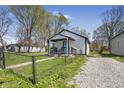 Charming home with a fenced yard and a gravel driveway on a sunny day at 2631 Collier St, Indianapolis, IN 46241