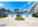 Inviting townhome exterior featuring light blue siding, white garages, and a vibrant green lawn at 3624 N Lakeside Dr, Muncie, IN 47304