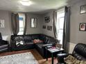 Comfortable living room with a large black leather sectional couch and two windows for natural light at 389 W Poston Rd, Martinsville, IN 46151