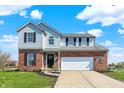 Beautiful home featuring a brick and vinyl facade, complete with an attached garage and manicured front lawn at 4827 Spring Flower Ct, Indianapolis, IN 46237