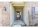 Inviting entryway with brick facade, covered porch, and a modern black front door with glass detail at 5083 Castamere Dr, Noblesville, IN 46062