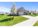 Attractive brick home with a two-car garage and a beautifully maintained lawn in a suburban neighborhood at 5083 Castamere Dr, Noblesville, IN 46062