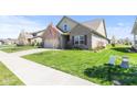 Beautifully landscaped front yard with lush green grass and a sidewalk leading to a brick and siding home at 5083 Castamere Dr, Noblesville, IN 46062