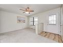 Bright living room features a ceiling fan, a large window, carpeted floors, and a rear entrance at 509 Nelson Dr, Brownsburg, IN 46112