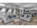 Well-lit living room showcases a modern design, comfortable seating, and seamless flow into the kitchen at 5157 Climbing Rose Pl, Indianapolis, IN 46254